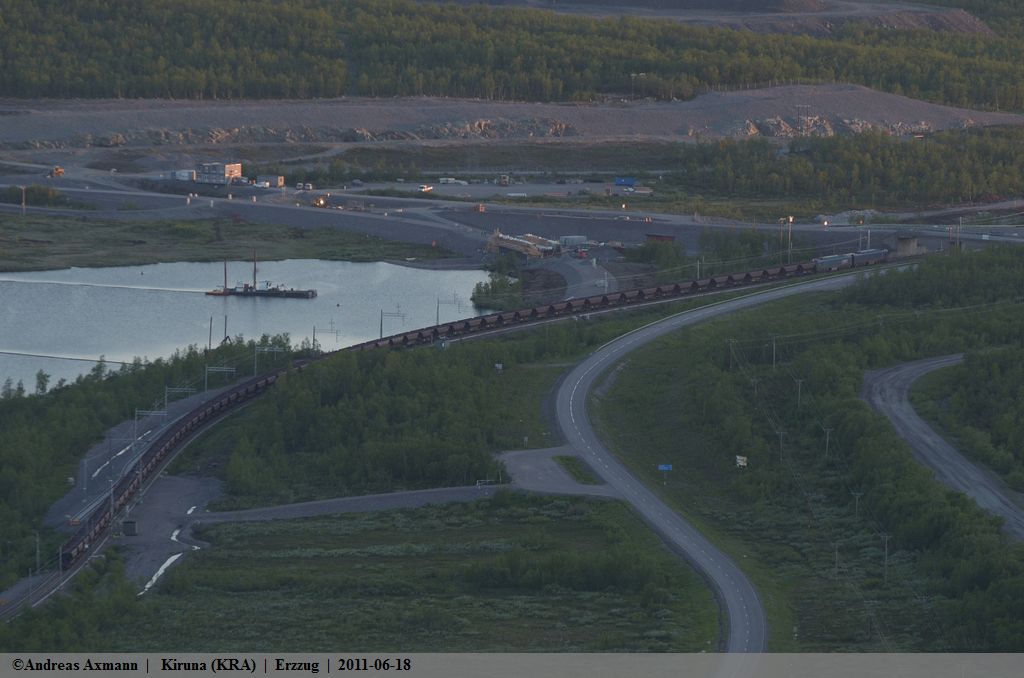 Einer Schlange gleichend, fhrt eine Doppellok als 9902 um 00:07 Uhr mit vollen Erzwagen auf der 641.001 von Kiruna Malmbangrd kommend auf ihrer fahrt nach Narvik(NK) am Luossavaara vorbei. (17,06,2011)